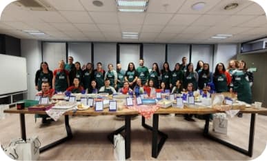 team of people posing for a photo with green cooking aprons