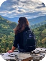 woman posing with flat rock technology backpack